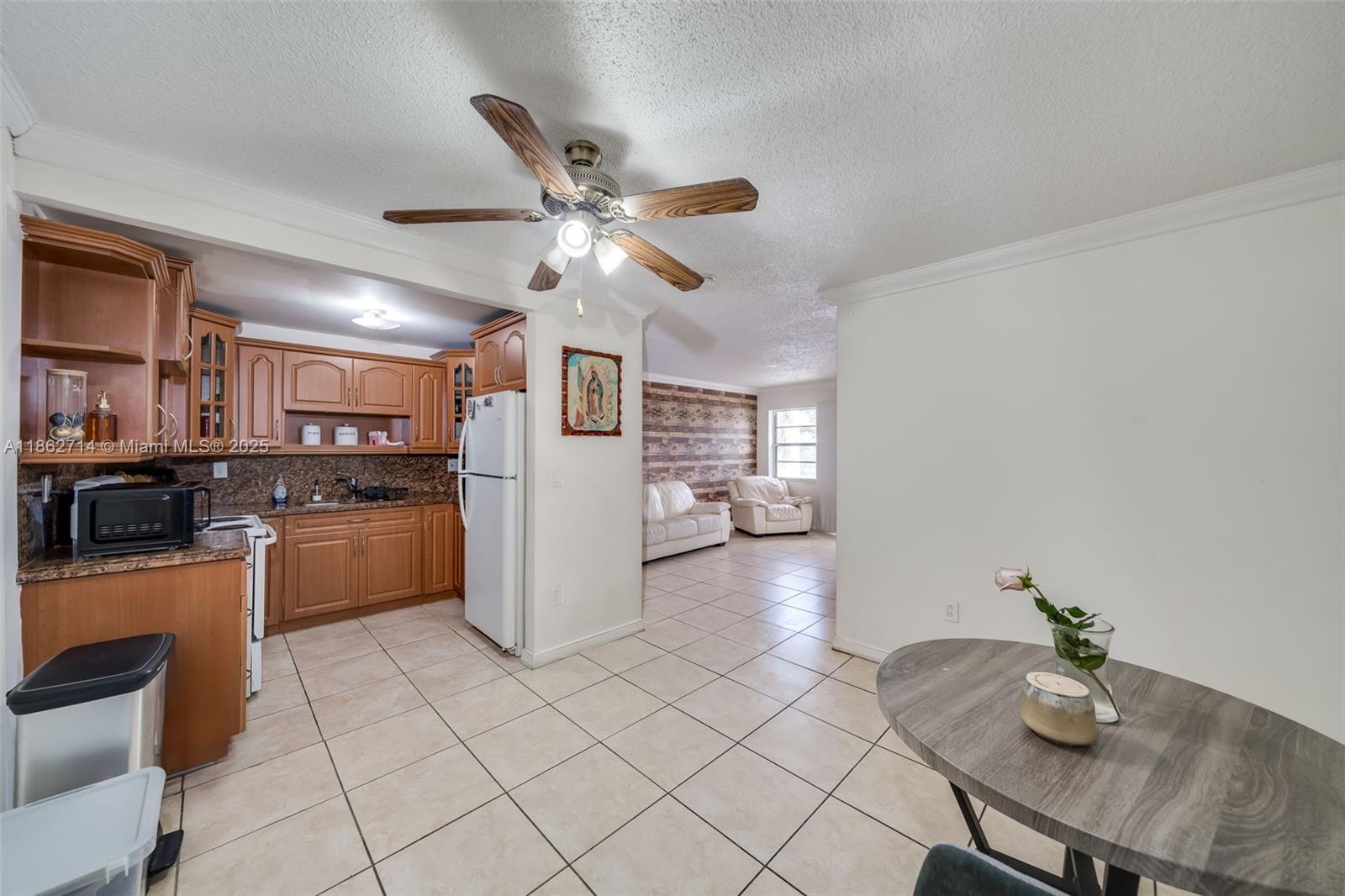 1221 Southwest 122nd Avenue, Unit 215 Miami, FL 33184 - Photo 13 of 57 a kitchen with stainless steel appliances kitchen island granite countertop a sink cabinets and microwave