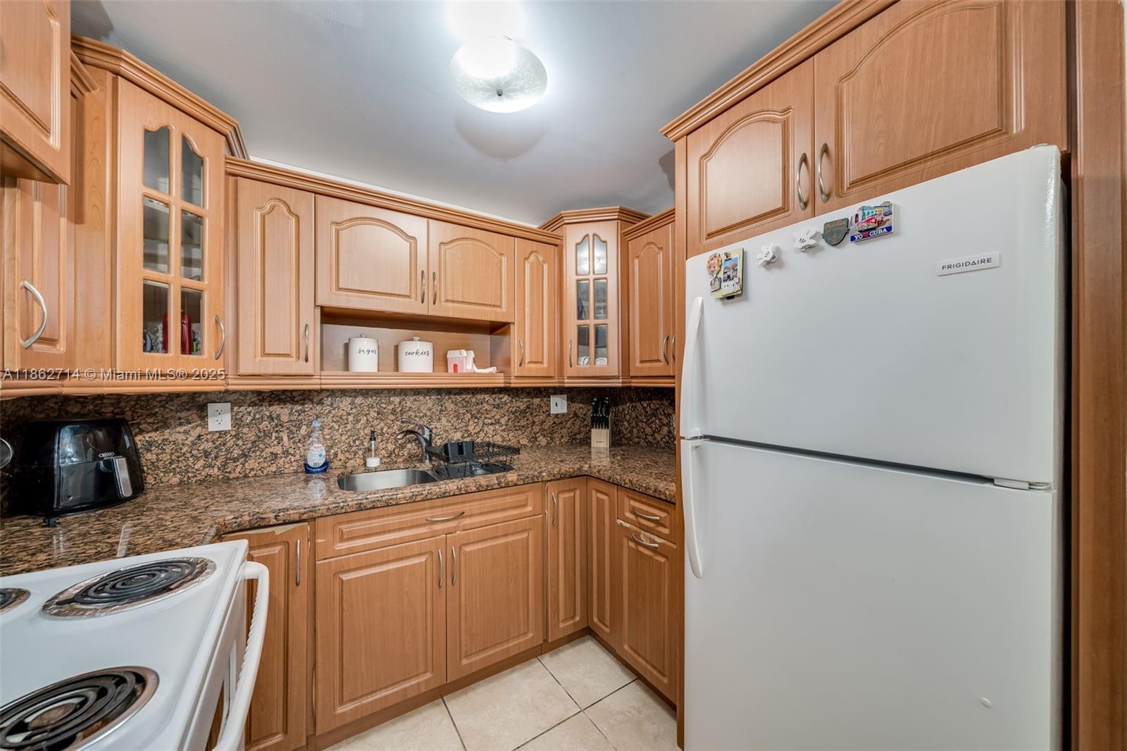 1221 Southwest 122nd Avenue, Unit 215 Miami, FL 33184 - Photo 18 of 57 a kitchen with stainless steel appliances a refrigerator sink and cabinets