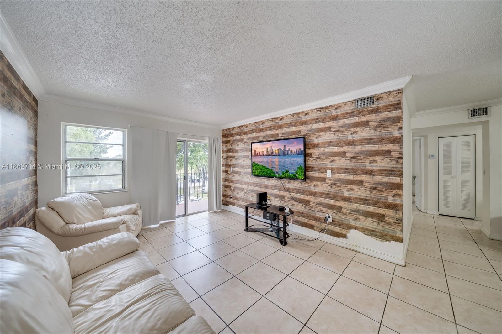 1221 Southwest 122nd Avenue, Unit 215 Miami, FL 33184 - Photo 22 of 57 a living room with furniture and a flat screen tv