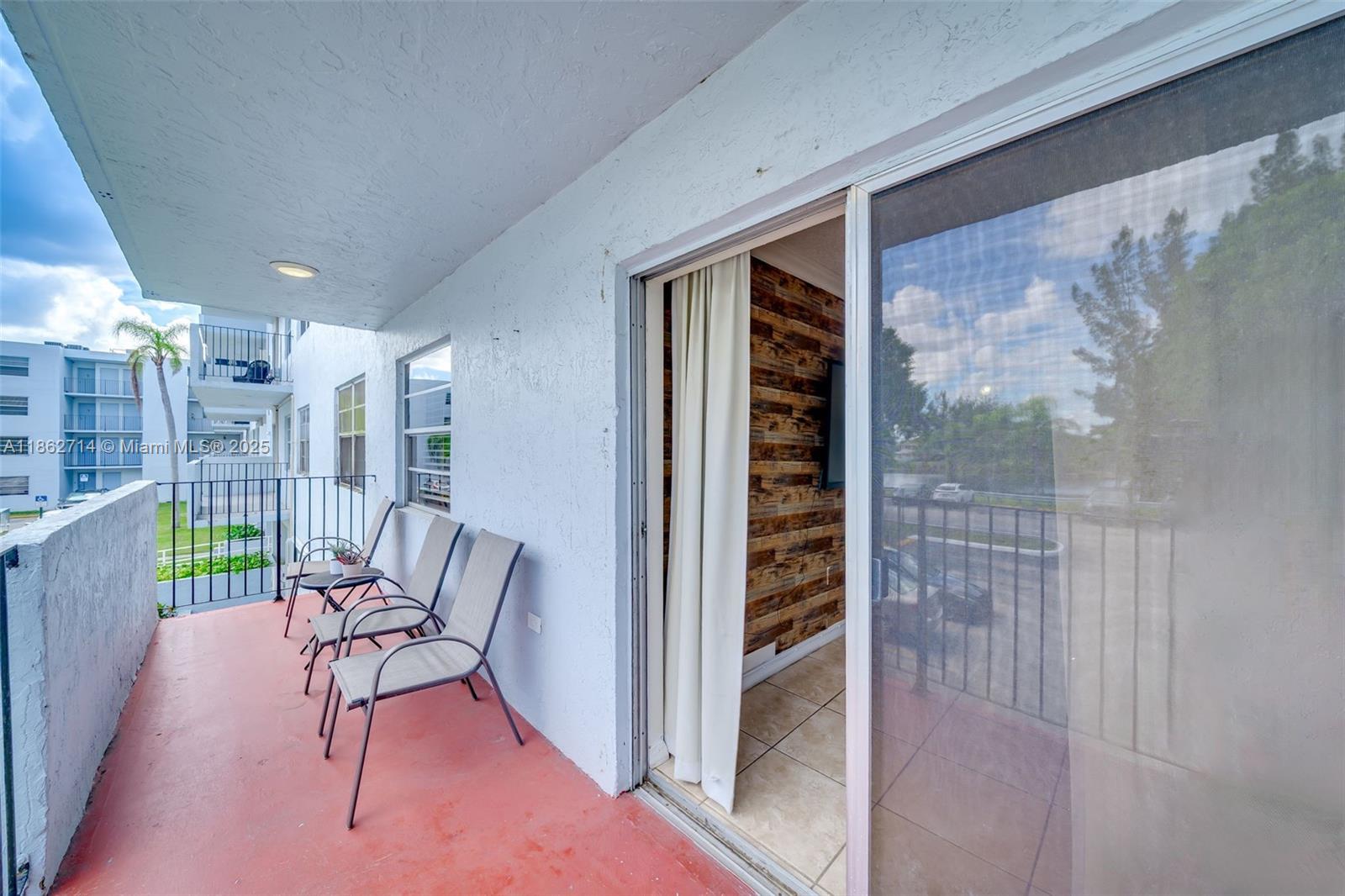 1221 Southwest 122nd Avenue, Unit 215 Miami, FL 33184 - Photo 26 of 57 a view of a hallway with chairs and table in a patio