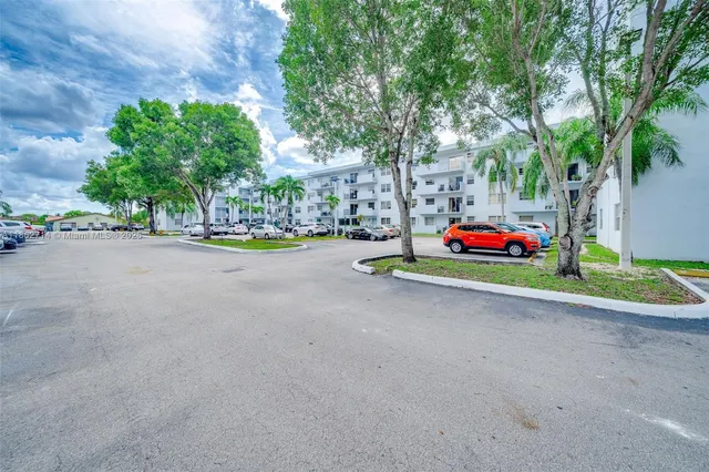 a view of a big building with a big yard and large trees