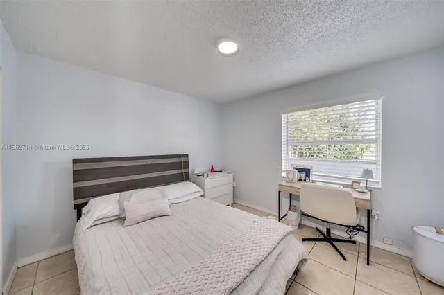 a bedroom with a bed and a large mirror