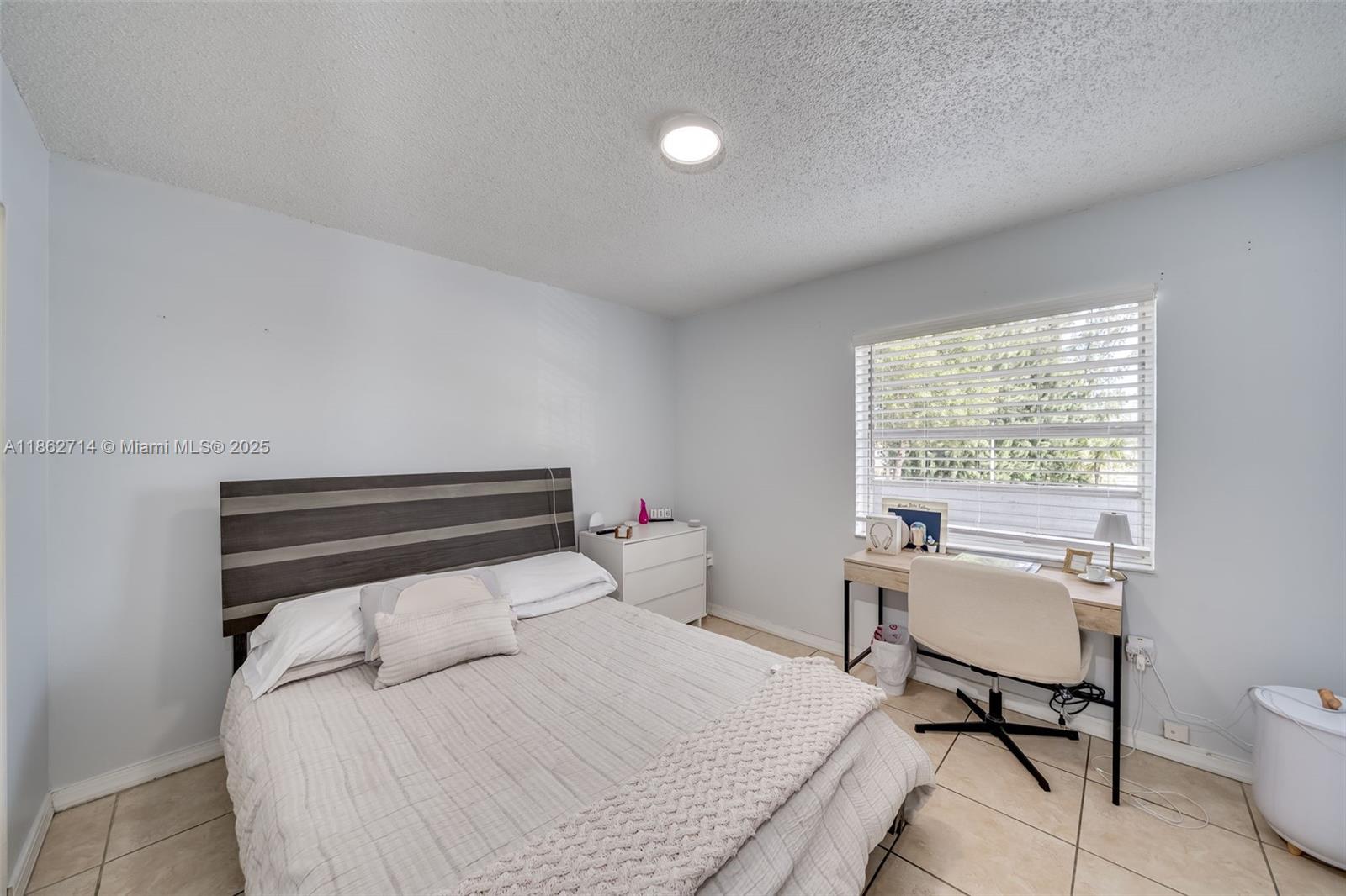 1221 Southwest 122nd Avenue, Unit 215 Miami, FL 33184 - Photo 32 of 57 a bedroom with a bed and a desk