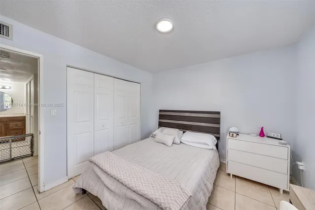 a bedroom with a bed and a potted plant