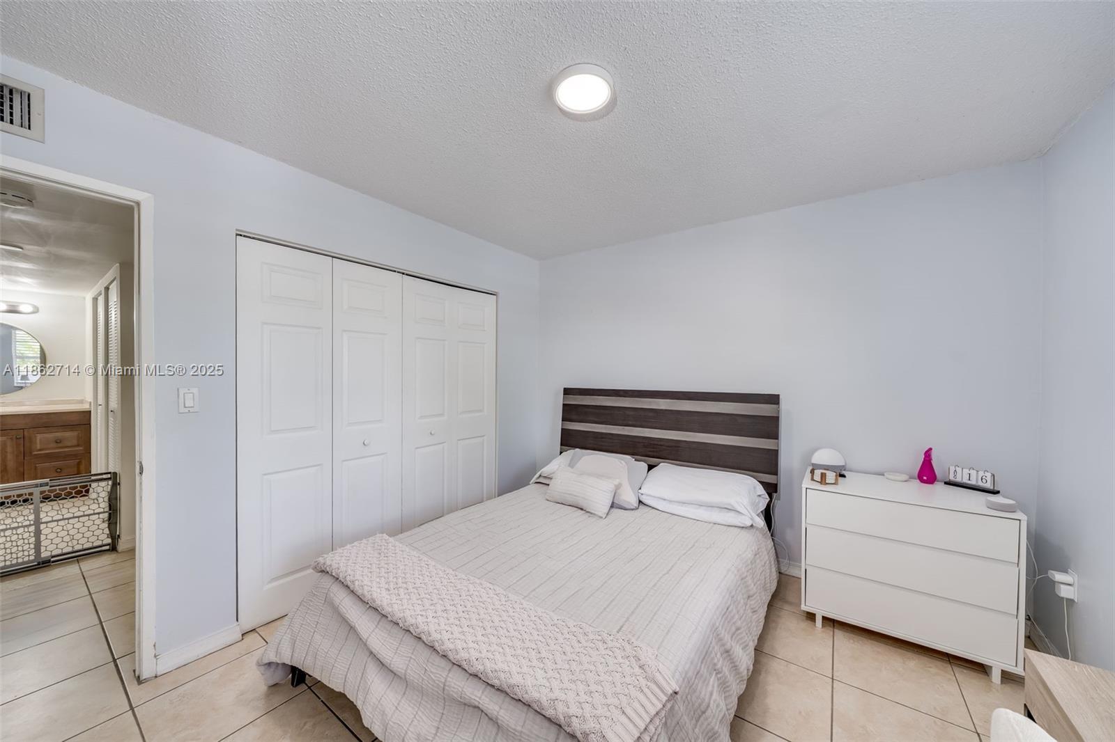 1221 Southwest 122nd Avenue, Unit 215 Miami, FL 33184 - Photo 33 of 57 a bedroom with a bed and cabinets