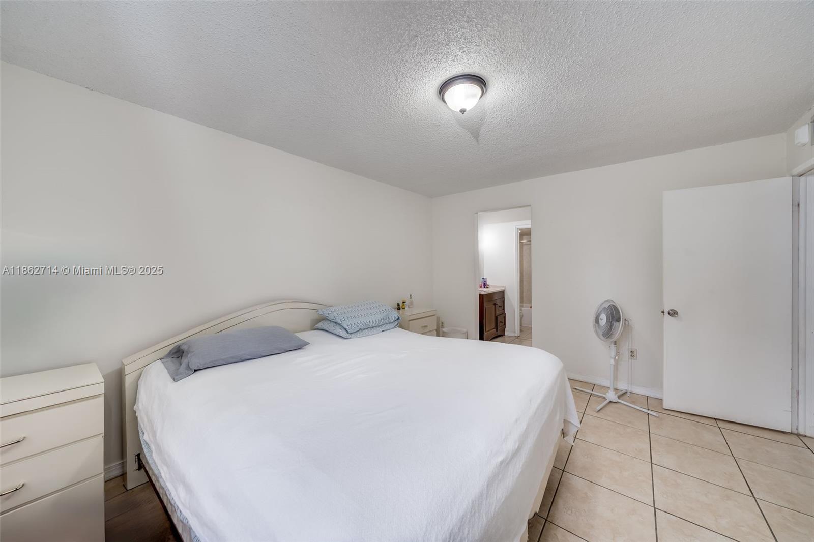1221 Southwest 122nd Avenue, Unit 215 Miami, FL 33184 - Photo 36 of 57 a bedroom with a bed and a large mirror