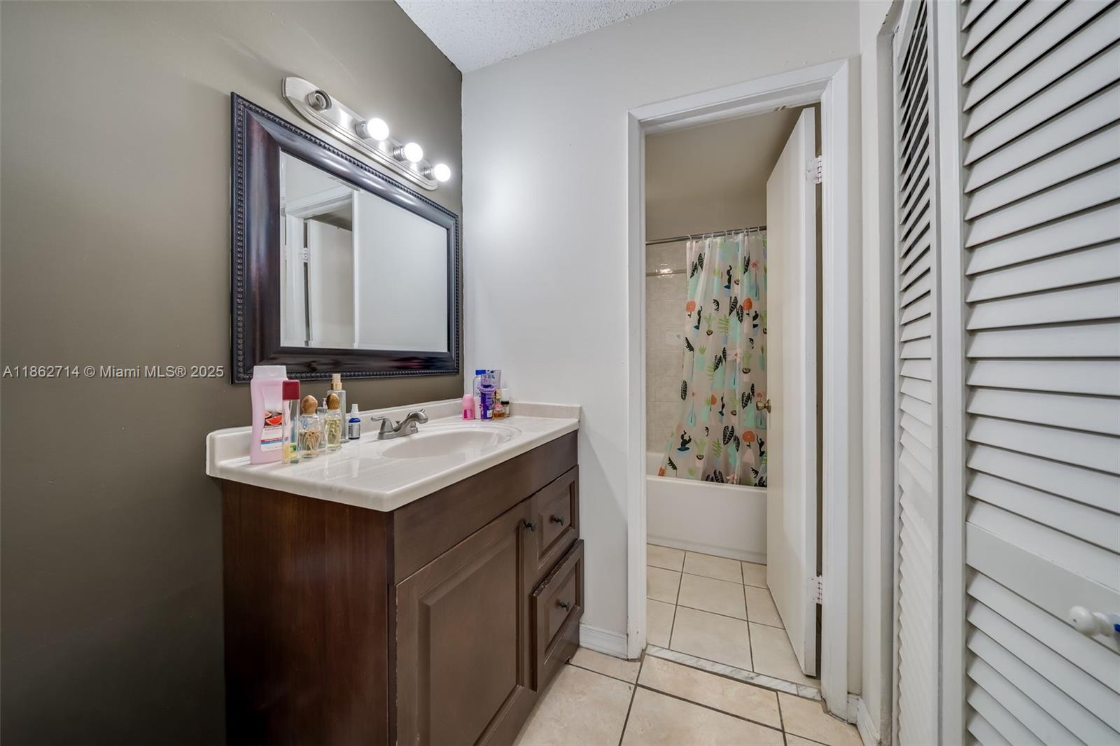1221 Southwest 122nd Avenue, Unit 215 Miami, FL 33184 - Photo 38 of 57 a bathroom with a sink a vanity and a mirror