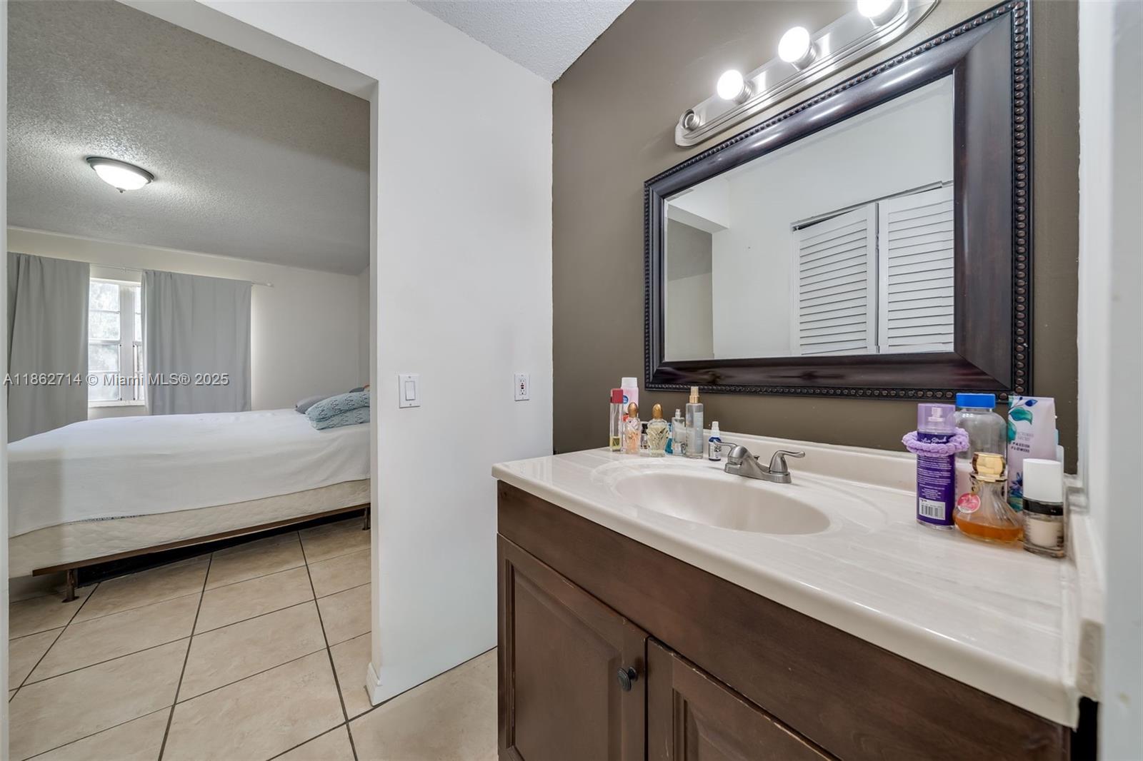 1221 Southwest 122nd Avenue, Unit 215 Miami, FL 33184 - Photo 39 of 57 a en suite bathroom with a double vanity sink and a mirror