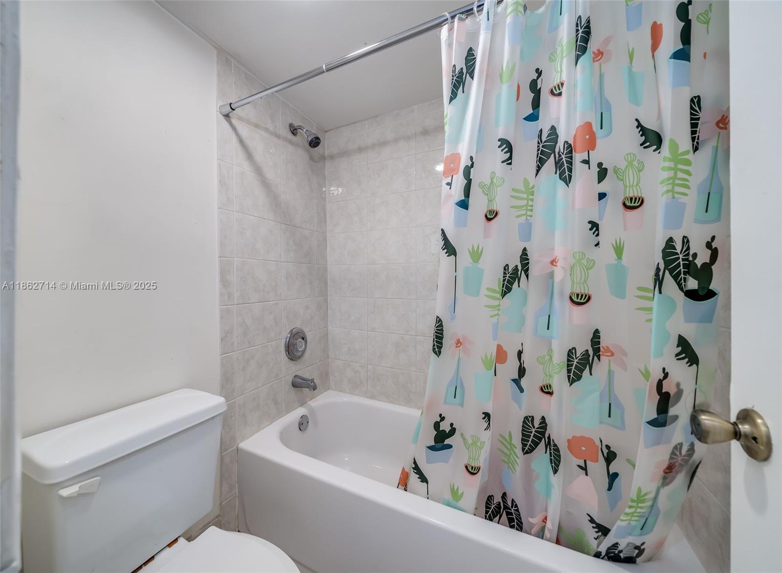 1221 Southwest 122nd Avenue, Unit 215 Miami, FL 33184 - Photo 40 of 57 a bathroom with a bathtub and shower curtain