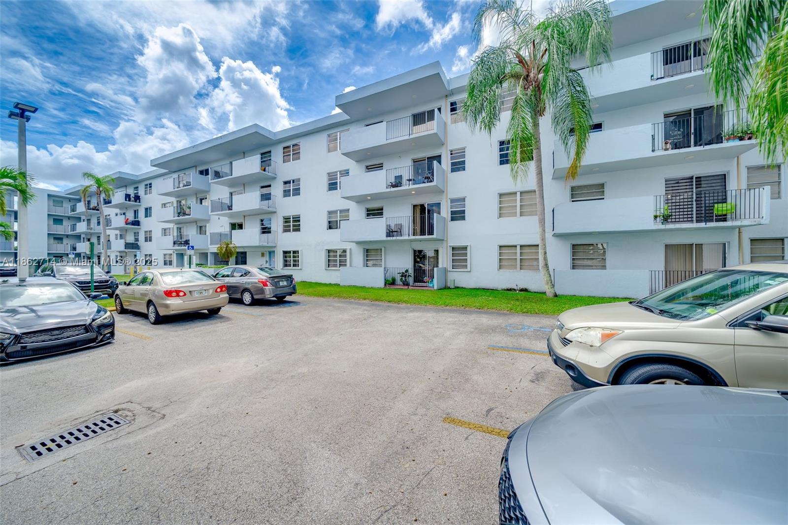 1221 Southwest 122nd Avenue, Unit 215 Miami, FL 33184 - Photo 7 of 57 a view of a cars park in front of a building