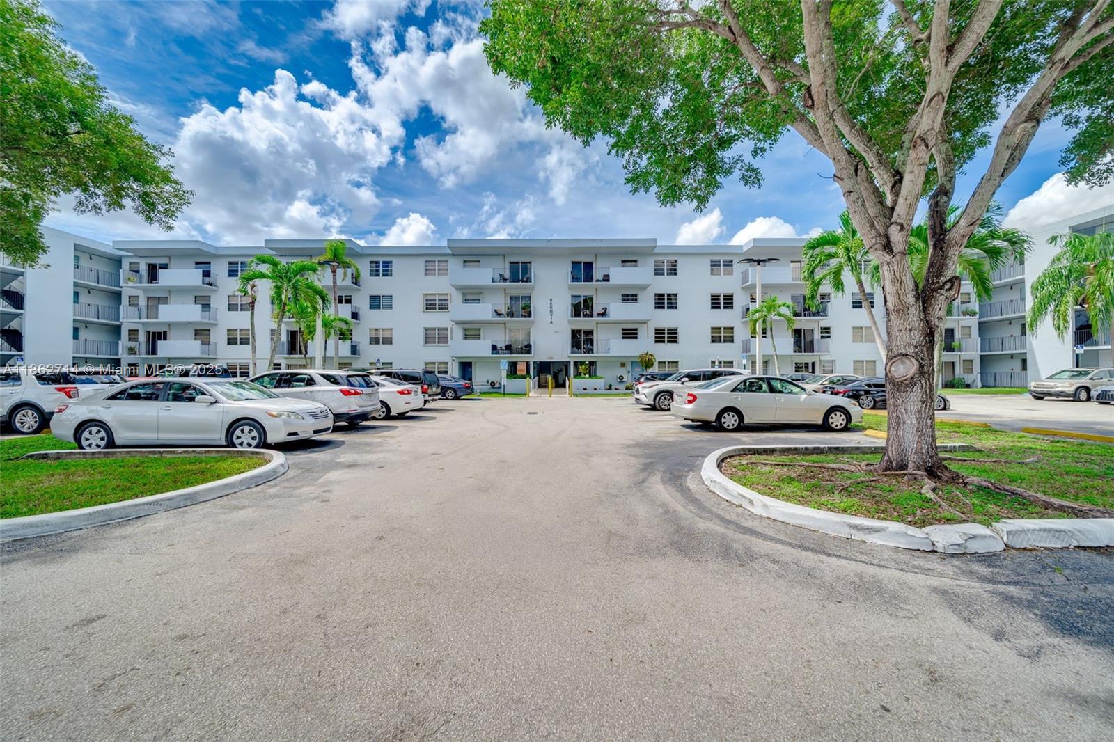 1221 Southwest 122nd Avenue, Unit 215 Miami, FL 33184 - Photo 8 of 57 a cars parked in front of a building