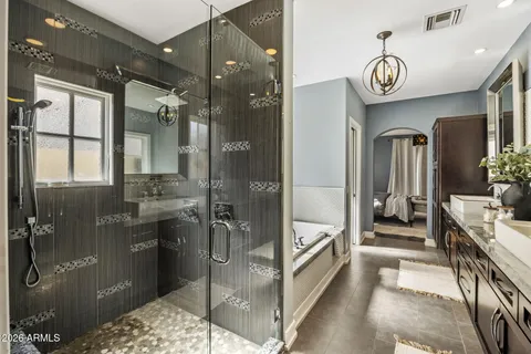a bathroom with a tub a mirror and a shower