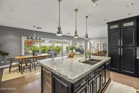 a kitchen with a stove a kitchen island a table and chairs