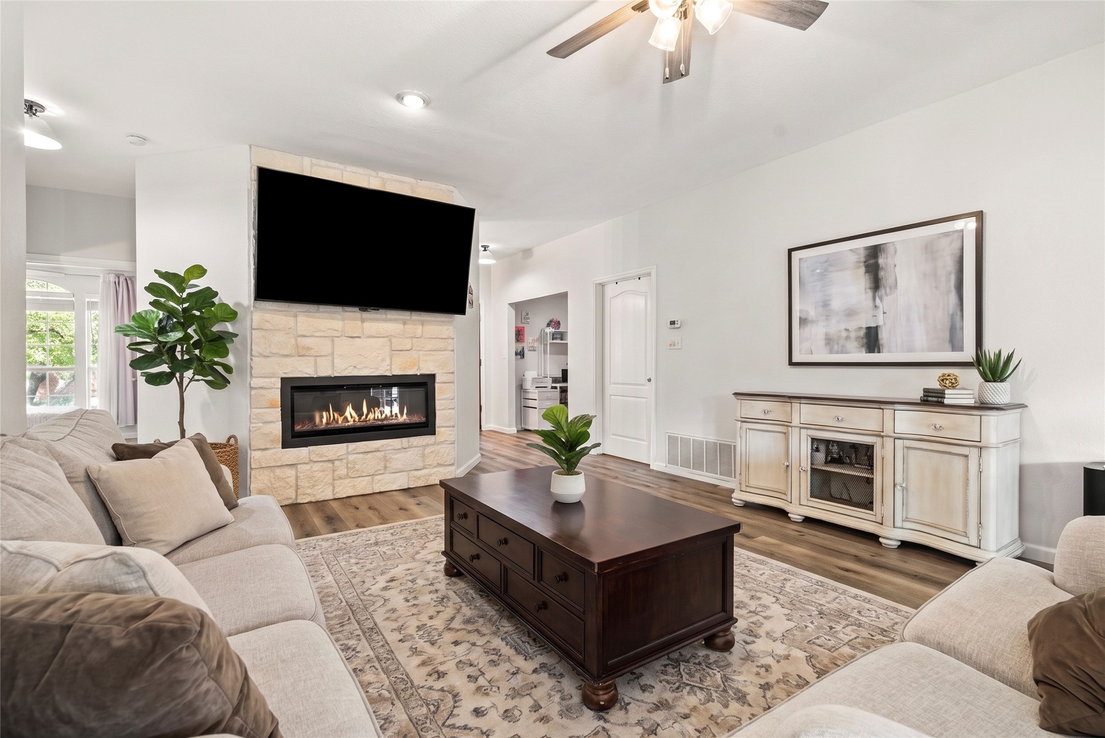 9024 Heiden Lane Austin, TX 78749 - Photo 2 of 33 The living room opens up as a spacious gathering spot, anchored by a beautiful stone-faced electric fireplace that brings a sense of warmth to the entire room