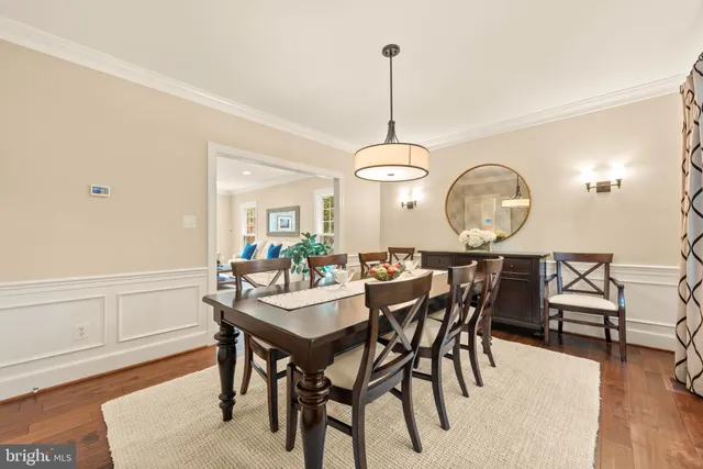 a kitchen with stainless steel appliances granite countertop a table chairs stove and a wooden floors