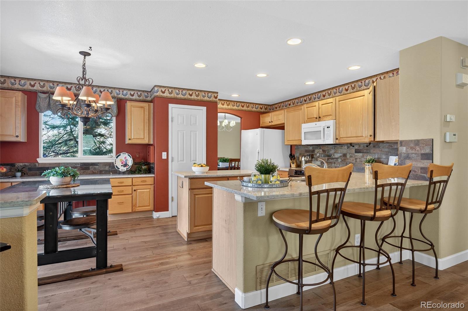747 West Sparrow Hawk Drive Highlands Ranch, CO 80129 - Photo 19 of 50 a kitchen with a table chairs stove and cabinets