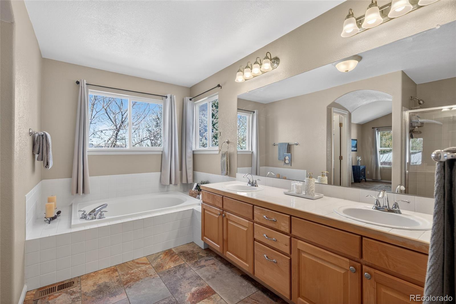 747 West Sparrow Hawk Drive Highlands Ranch, CO 80129 - Photo 29 of 50 a bathroom with a tub double sink window and mirror