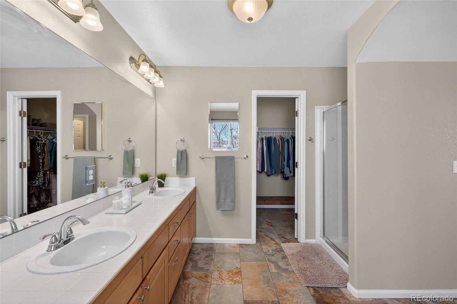 747 West Sparrow Hawk Drive Highlands Ranch, CO 80129 - Photo 30 of 50 a spacious bathroom with a double vanity sink and a mirror