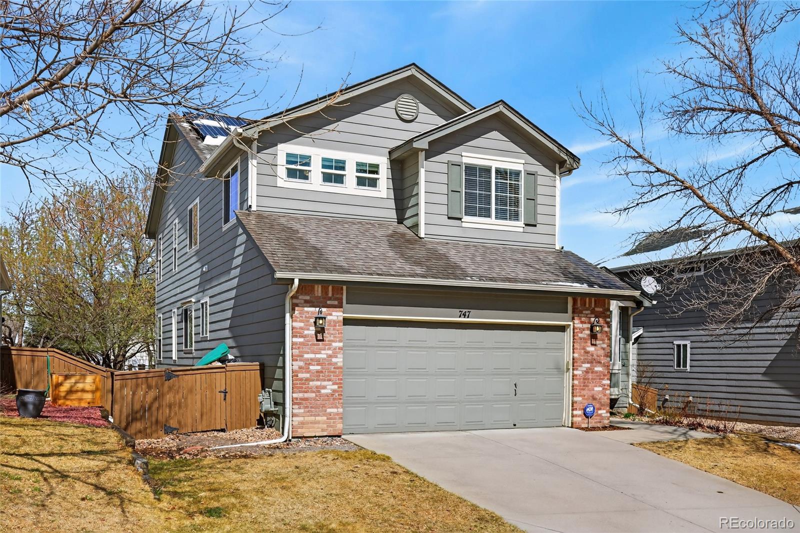 747 West Sparrow Hawk Drive Highlands Ranch, CO 80129 - Photo 48 of 50 a front view of a house with a yard and garage