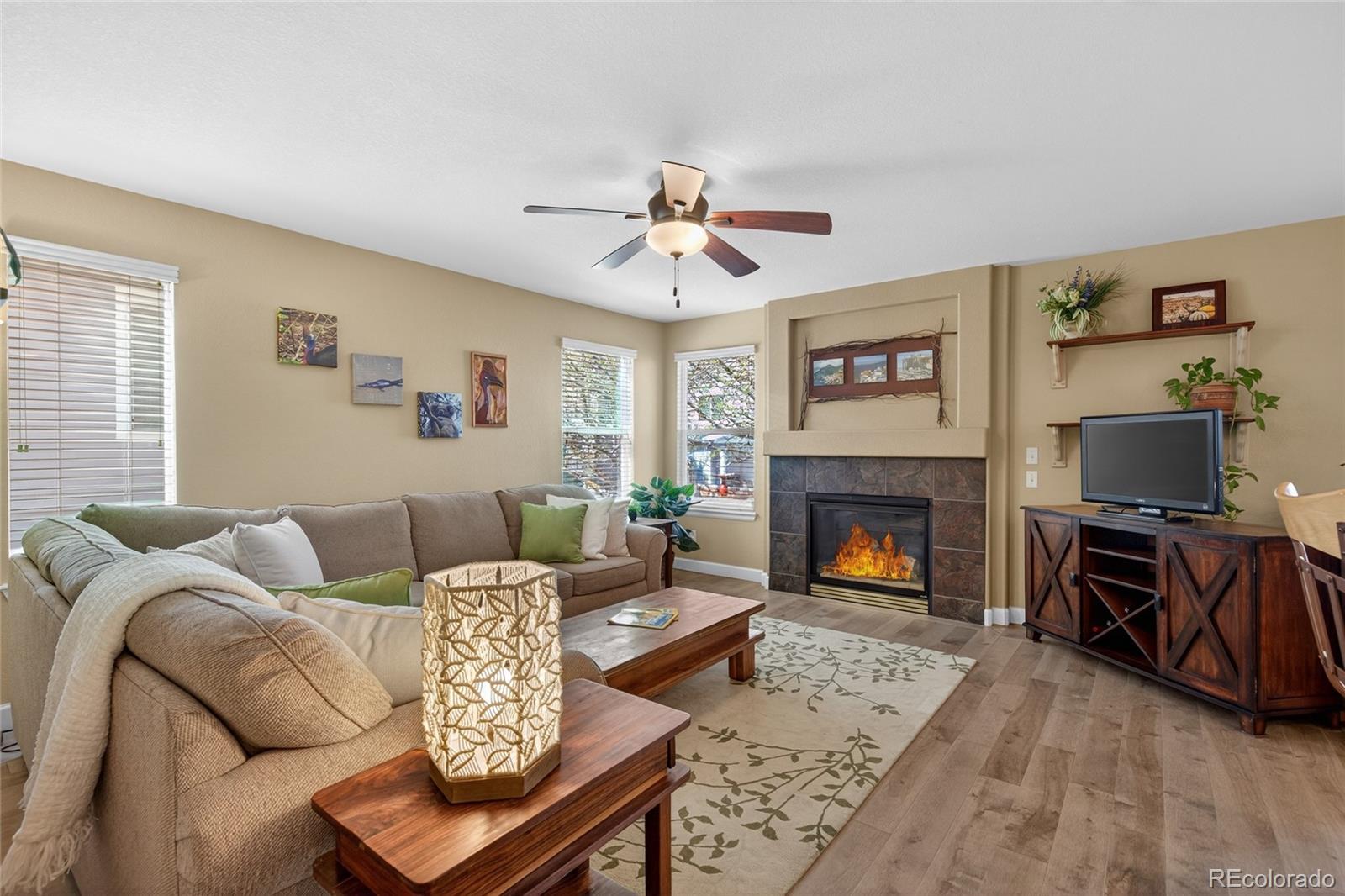 747 West Sparrow Hawk Drive Highlands Ranch, CO 80129 - Photo 7 of 50 a living room with furniture a fireplace and a flat screen tv