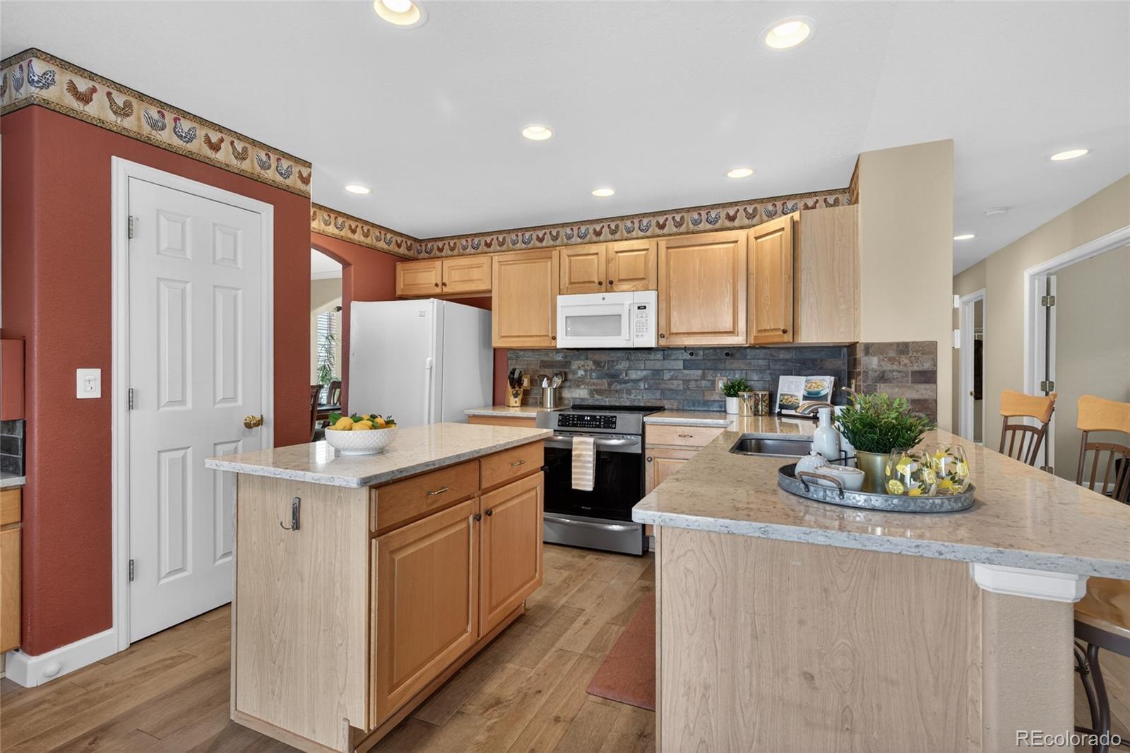 747 West Sparrow Hawk Drive Highlands Ranch, CO 80129 - Photo 8 of 50 a kitchen with a stove top oven a sink a counter top space and cabinets