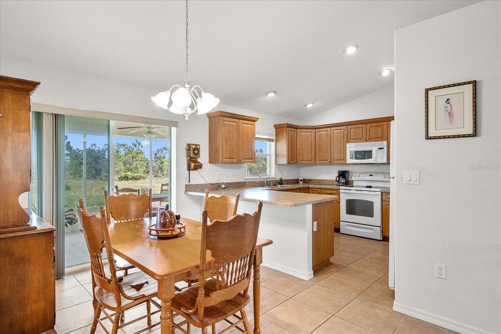 30 Milky Way Venus, FL 33960 - Photo 7 of 47 a dining room filled a chandelier a large window and a kitchen view