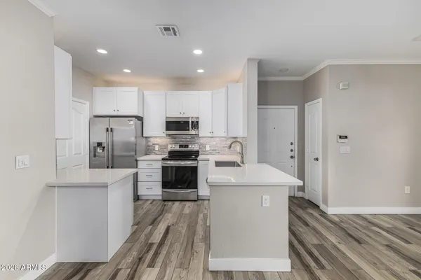 a kitchen with refrigerator cabinets and wooden floor
