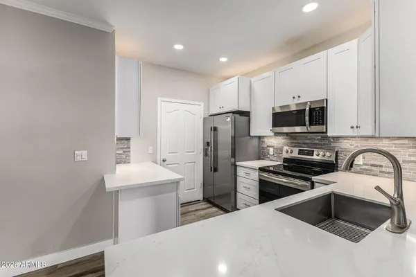 a kitchen with refrigerator a stove a sink and a microwave