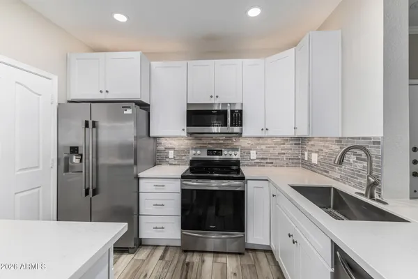 a kitchen with white cabinets and stainless steel appliances