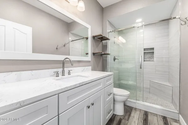 a bathroom with a sink a toilet and shower