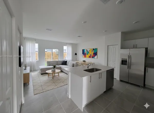 a kitchen with stainless steel appliances granite countertop a sink and a refrigerator