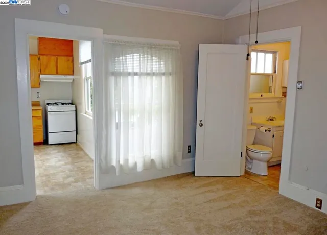 a view of an empty room with a fireplace and a window