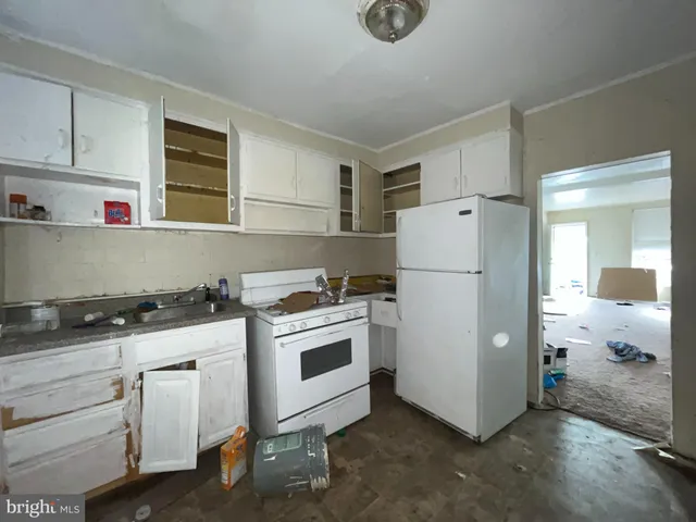 a white refrigerator freezer and a stove sitting inside of a kitchen