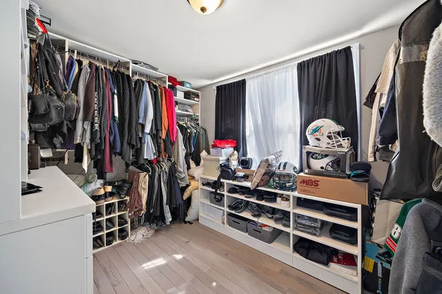 a view of walk in closet with clothes and shoes
