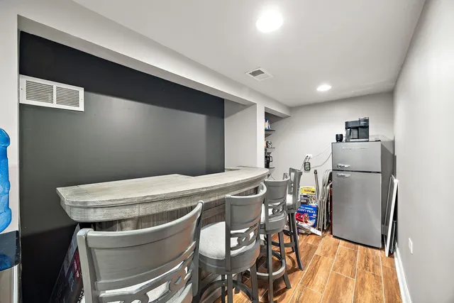 a room with stainless steel appliances a refrigerator and a table