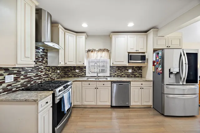 a kitchen with stainless steel appliances granite countertop a stove and a refrigerator