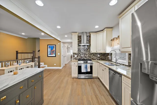 a large kitchen with stainless steel appliances granite countertop a lot of counter space and wooden floors