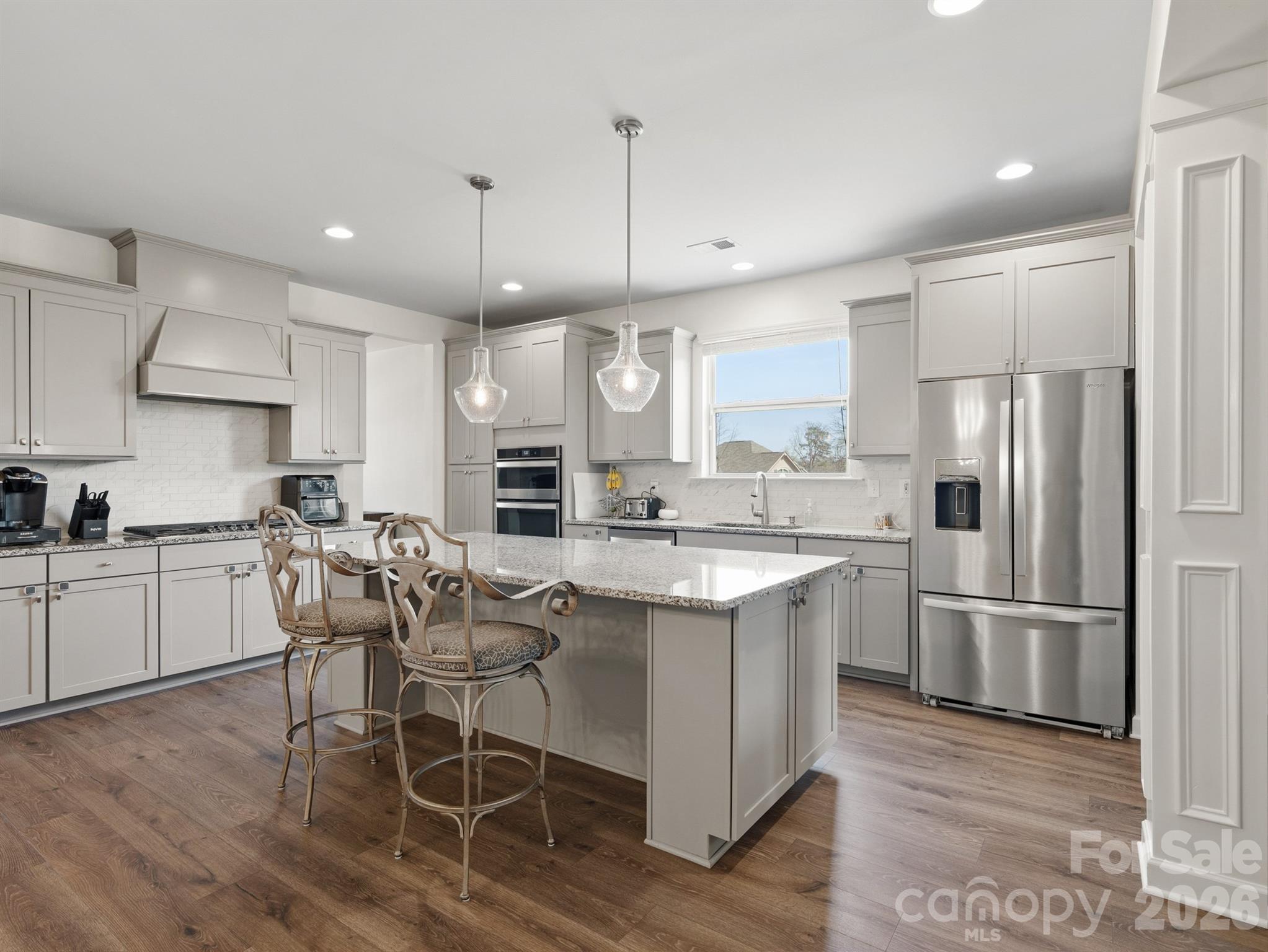 560 Sandbar Point Clover, SC 29710 - Photo 13 of 48 a kitchen with stainless steel appliances granite countertop a refrigerator a sink dishwasher a stove and white cabinets with wooden floor