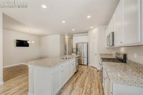 a large kitchen with stainless steel appliances granite countertop a large counter top and a stove top oven