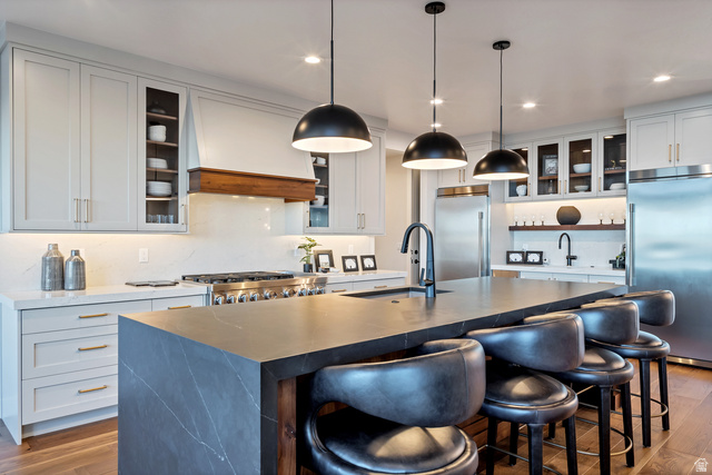 2145 North Main Street Centerville, UT 84014 - Photo 15 of 53 Kitchen featuring dark wood finished floors, built in fridge, a kitchen breakfast bar, and decorative light fixtures