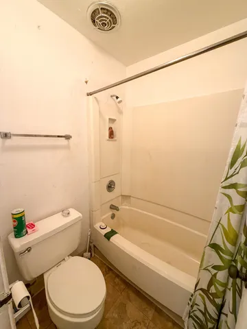 a white toilet and tub sitting next to a bathroom sink