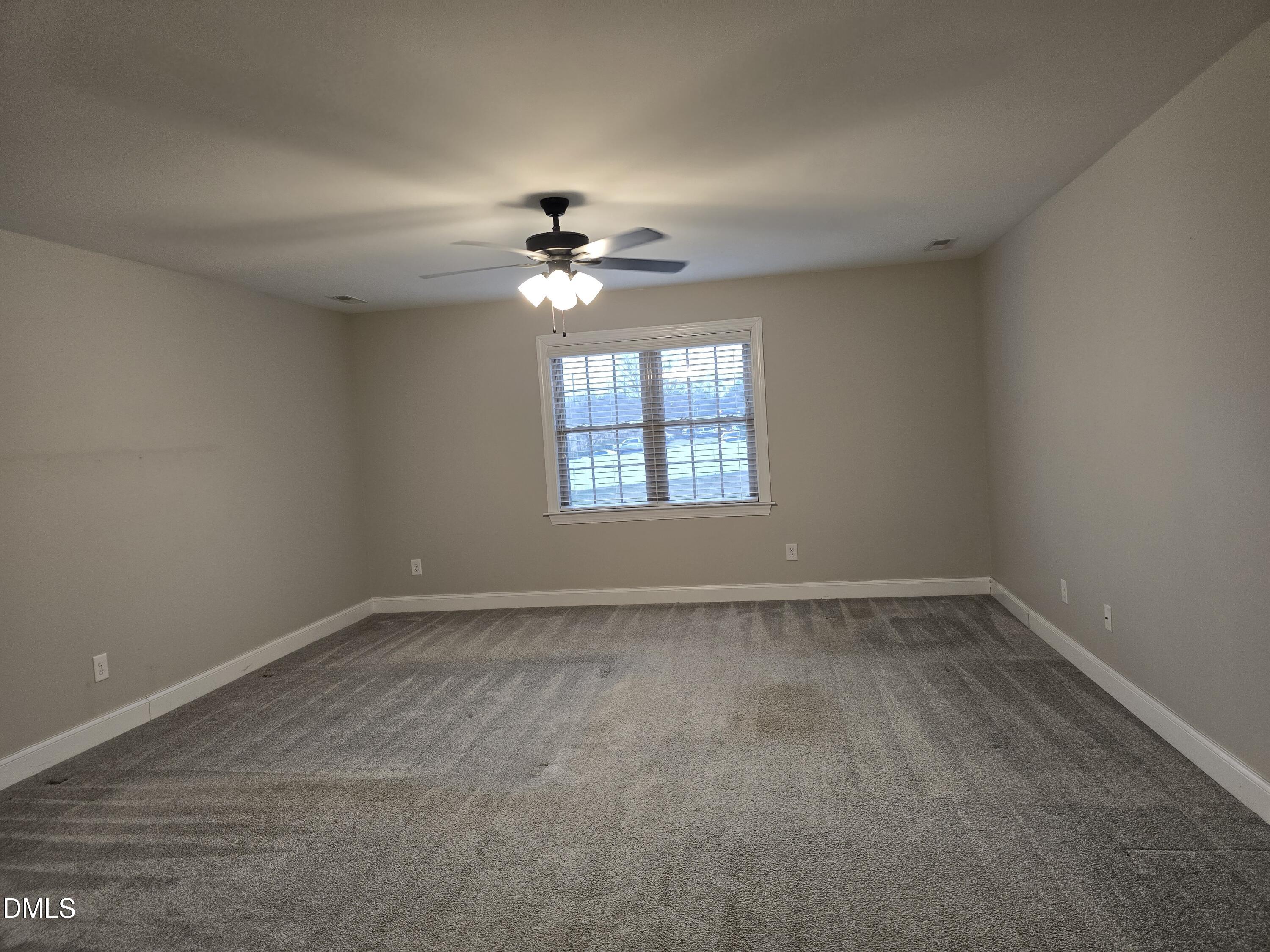933 Arrowhead Court Mebane, NC 27302 - Photo 60 of 84 an empty room with a window and a ceiling fan