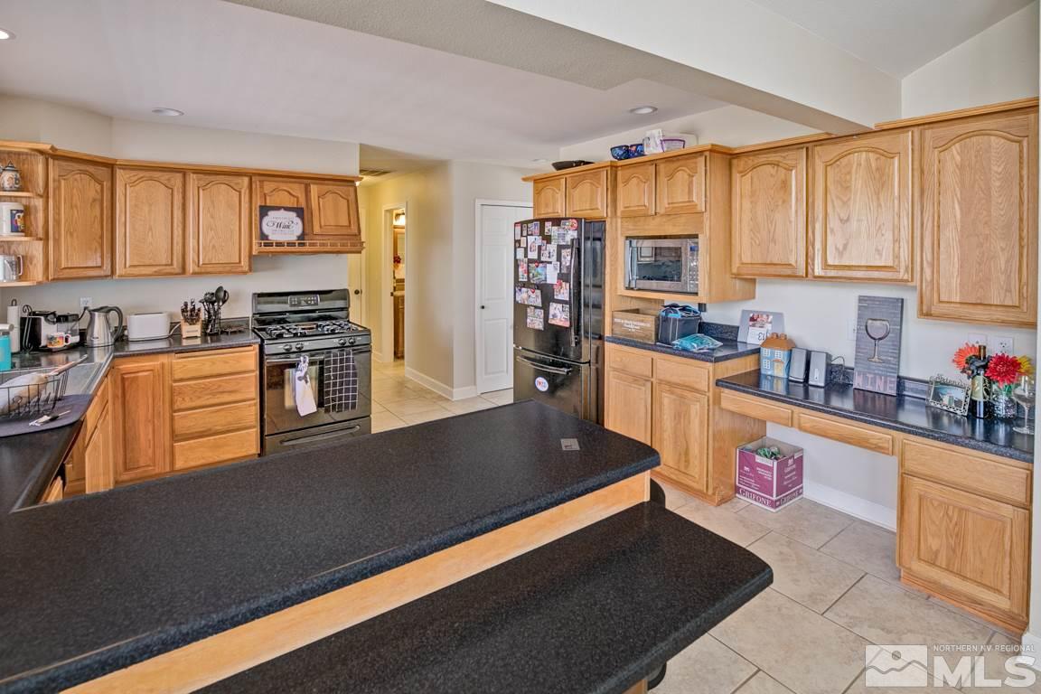 4100 Magnolia Road Fallon, NV 89406 - Photo 13 of 25 a kitchen with stainless steel appliances a stove refrigerator sink and cabinets