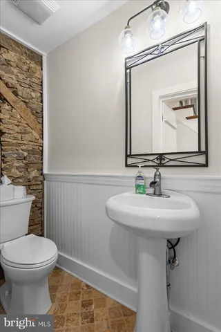 a bathroom with a toilet a sink and mirror