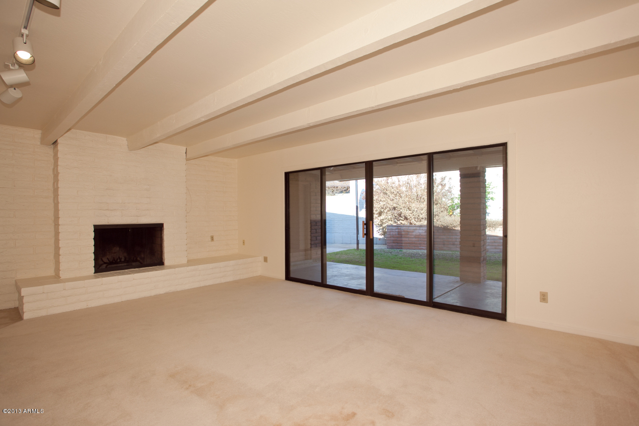4034 East Rancho Drive Phoenix, AZ 85018 - Photo 16 of 38 a view of an empty room with a fireplace and a window
