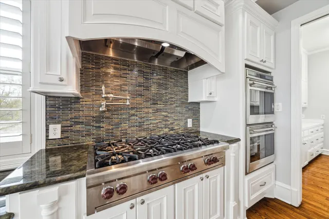 a kitchen with white cabinets and sink
