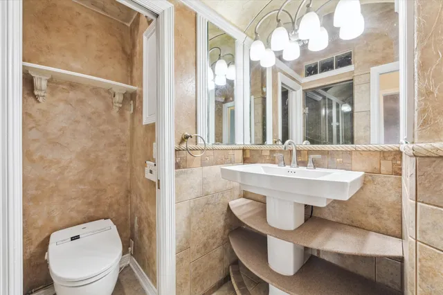 a bathroom with a sink a toilet a mirror and shower