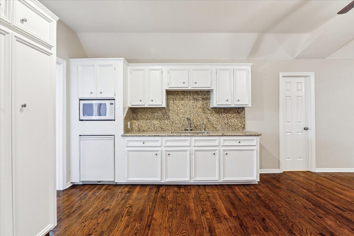 1406 Spring Cress Lane Seabrook, TX 77586 - Photo 32 of 50 a kitchen with granite countertop wooden cabinets and white appliances