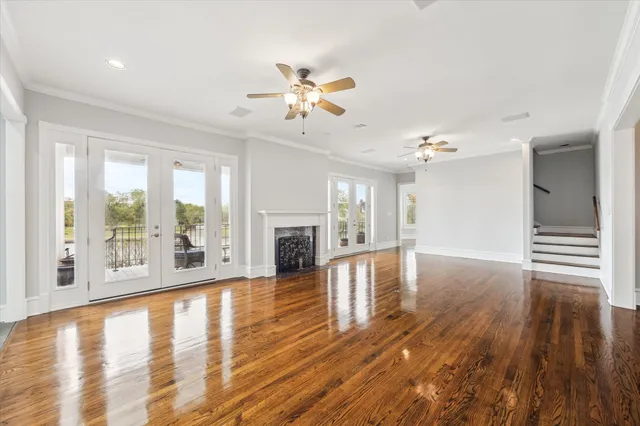 a view of an empty room with window and wooden floor