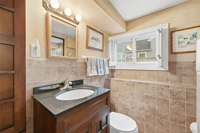 a bathroom with a granite countertop sink toilet and a mirror